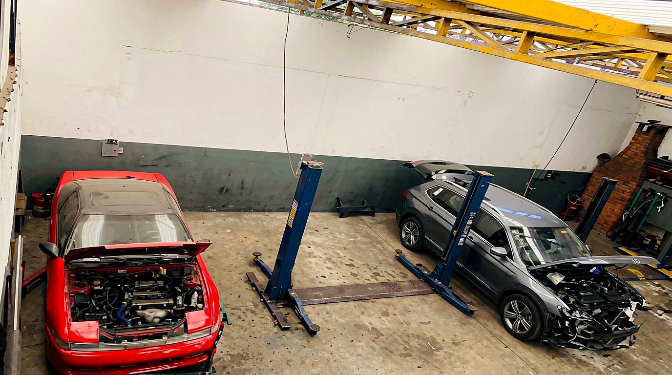 Vista interna da oficina Dom Sabatini com veículos em manutenção